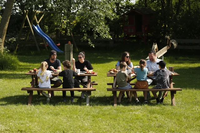 Familien frühstücken gemeinsam draußen auf unserem Ferienhof